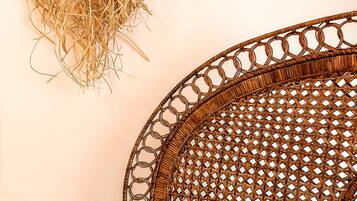 Una silla de mimbre con asiento circular tejido y un borde decorativo.