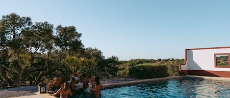 Een buitenzwembad, parasols voor strand/zwembad