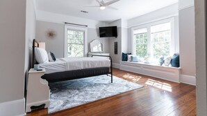 A bedroom with a bed, a desk, a chair, a window seat, and a ceiling fan. - Made for the trips that bring everyone together. This historic Montgomery home gives families, wedding parties, and groups room to gather, room to disappear for a while, and one place to come back to—all minutes from downtown, Maxwell AFB, and the re (Montgomery)