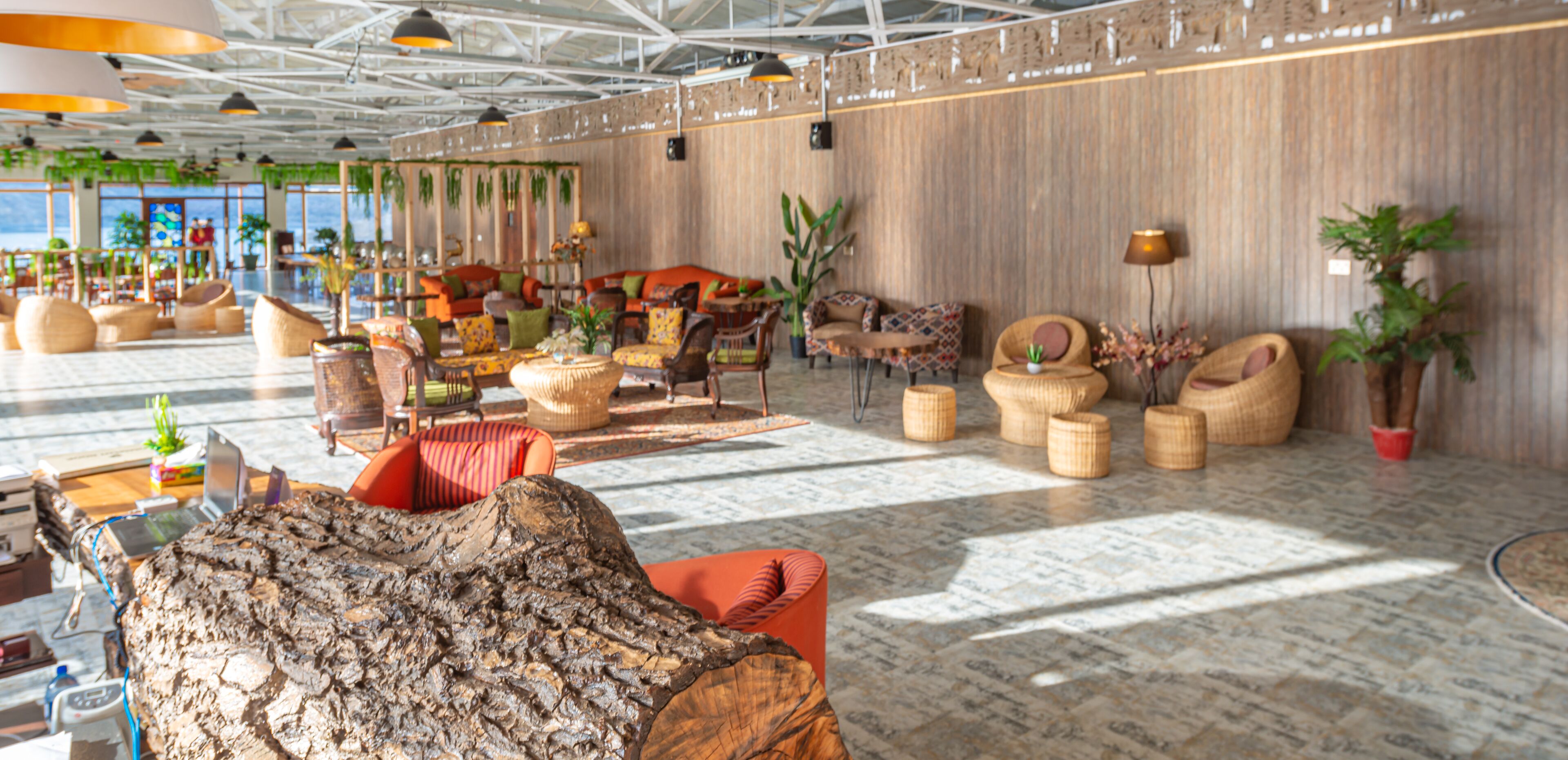 A spacious lobby with modern furniture, a large wooden sculpture, and a view of the outdoors.