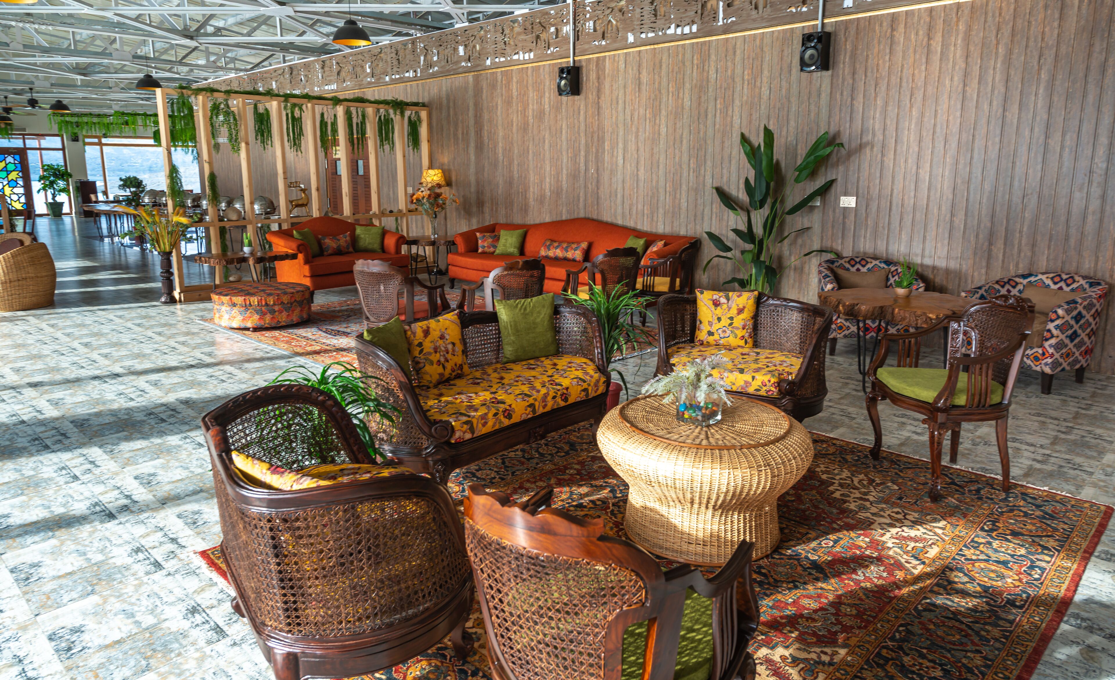 A spacious lobby with a large sofa, multiple chairs, and a patterned rug.
