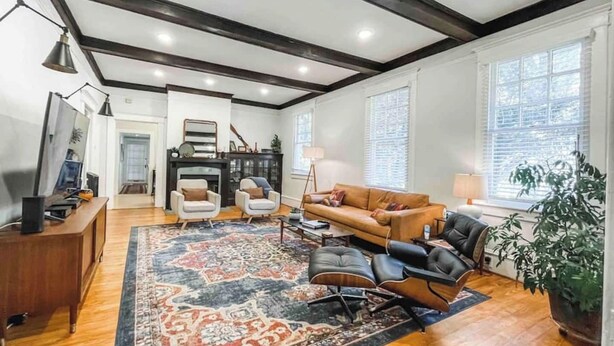 Un salon spacieux avec un grand tapis, une cheminée et un canapé.