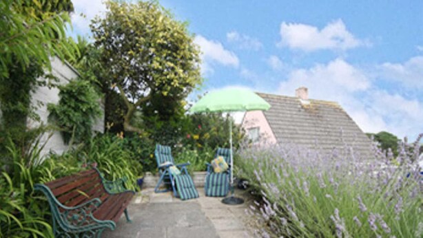 A garden patio with a bench, chairs, and an umbrella. - Detached House, 2 Bed, Sleeps 4, Parking (Fowey)