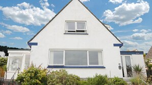 A white two-story house with a gable roof, a central window, and a door on the front. - Detached House, 2 Bed, Sleeps 4, Parking (Fowey)