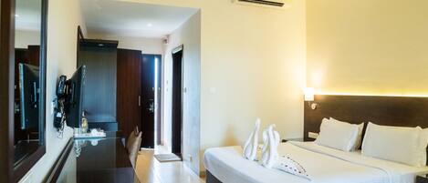 A hotel room with a bed, bedside table, and a mirror.