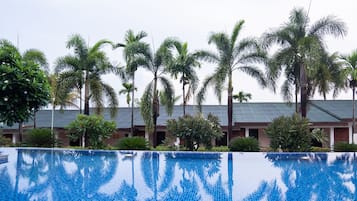 Una piscina al aire libre, sillones reclinables de piscina