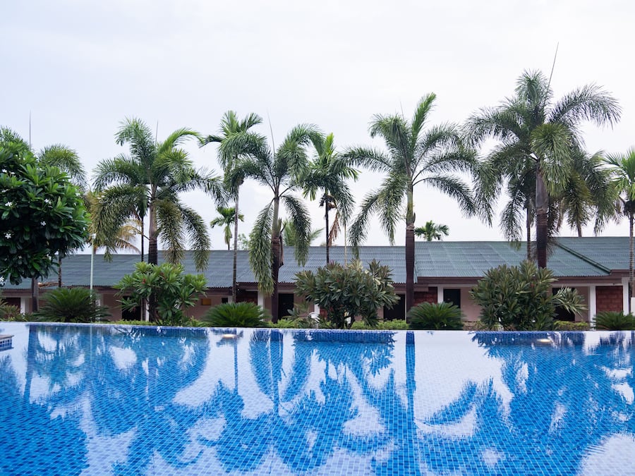 Una piscina al aire libre, sillones reclinables de piscina