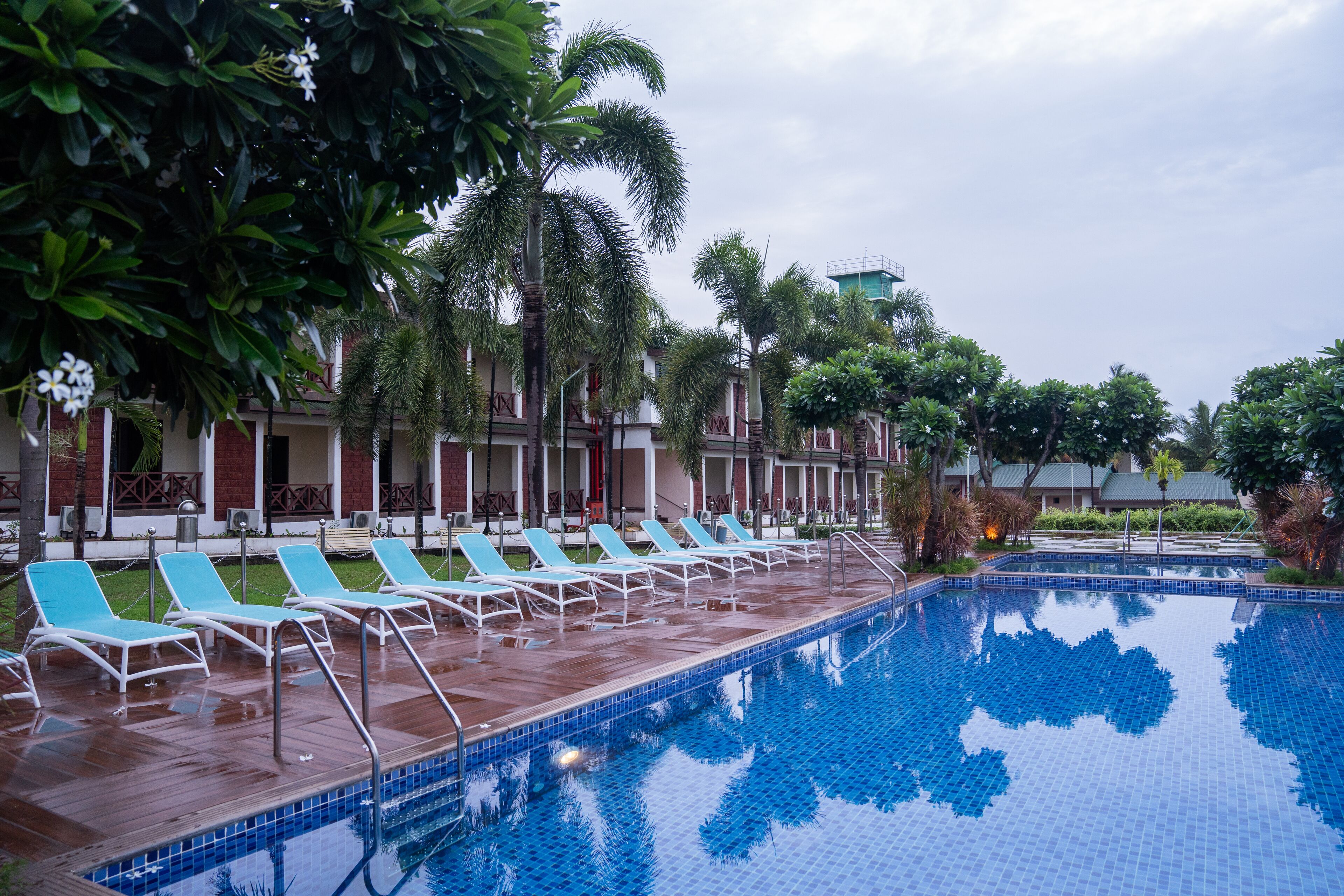 Ein Swimmingpool mit Liegestühlen und Palmen.