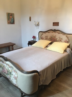 Une chambre à coucher avec un lit, une table de chevet, une lampe et un tableau au mur.