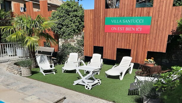 A villa with a sign reading "Villa Santucci On Est Bien Ici" and a pool area with lounge chairs. - Villa rental in APT (Apt)
