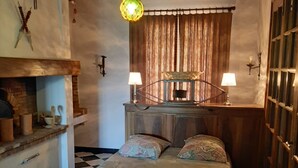 A bedroom with a checkered floor, a wooden bed frame, two bedside lamps, a wooden headboard, and a hanging light fixture. - Villa rental in APT (Apt)