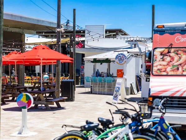 A street with outdoor seating, a food truck, and bicycles.