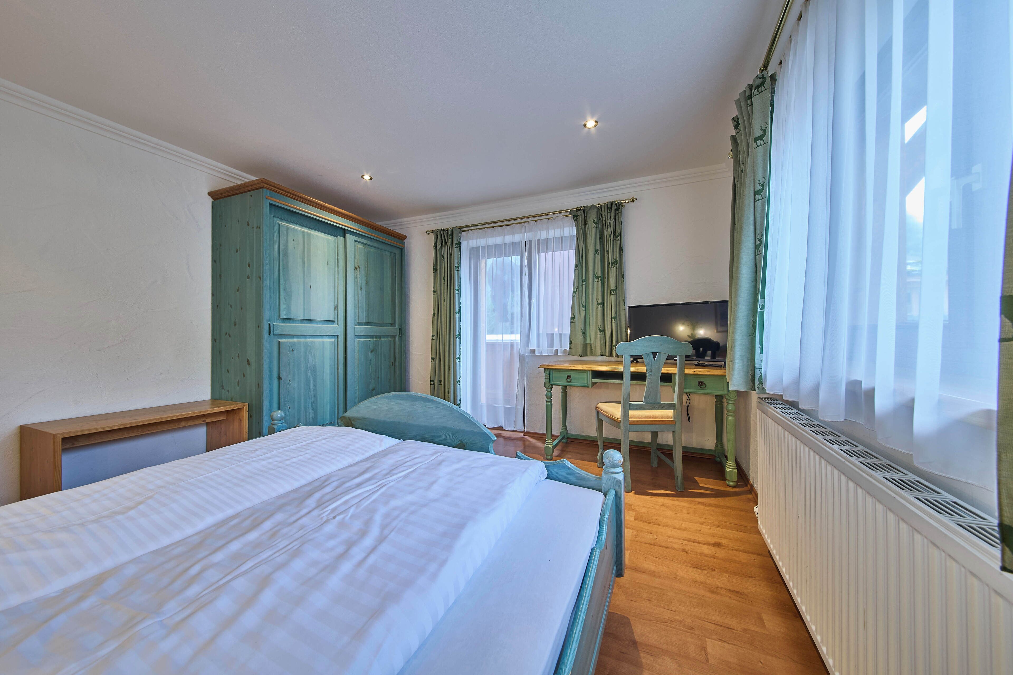 Ein Schlafzimmer mit einem Bett, einem Schreibtisch und einem Stuhl.