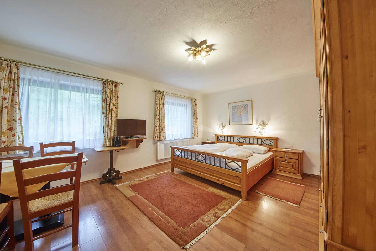 Une chambre à coucher avec un lit en bois, un bureau et une chaise.