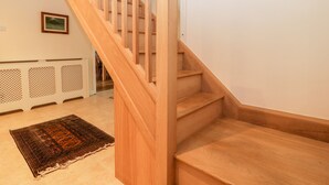 A wooden staircase with a handrail, leading to an upper floor. - Sherpa (Romsey)