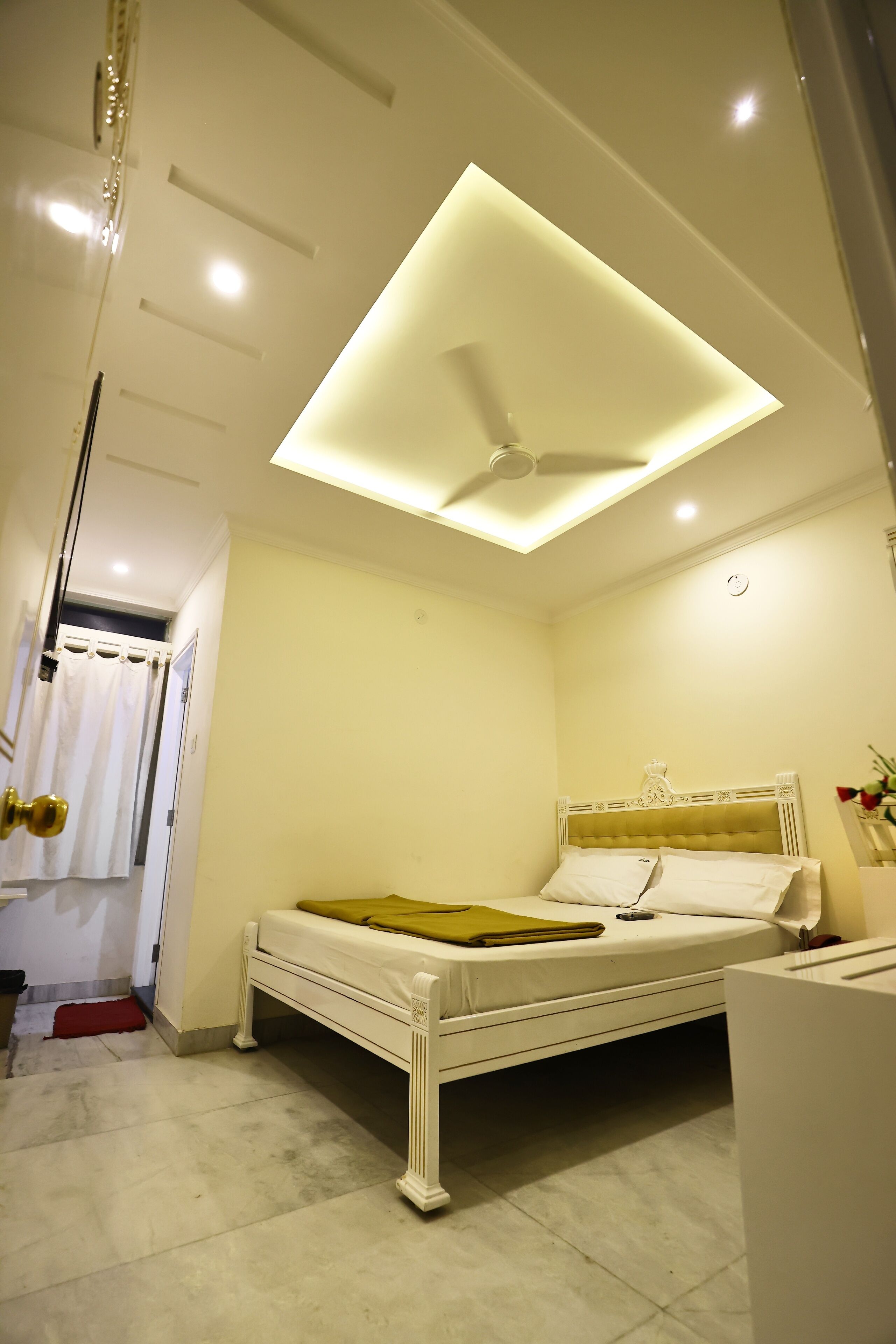 A bedroom with a bed, a ceiling fan, and a bedside table.