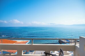 A balcony with a view of the sea, a flag, and a tiled roof. - Argo Rooms - Papadakis (Kissamos)