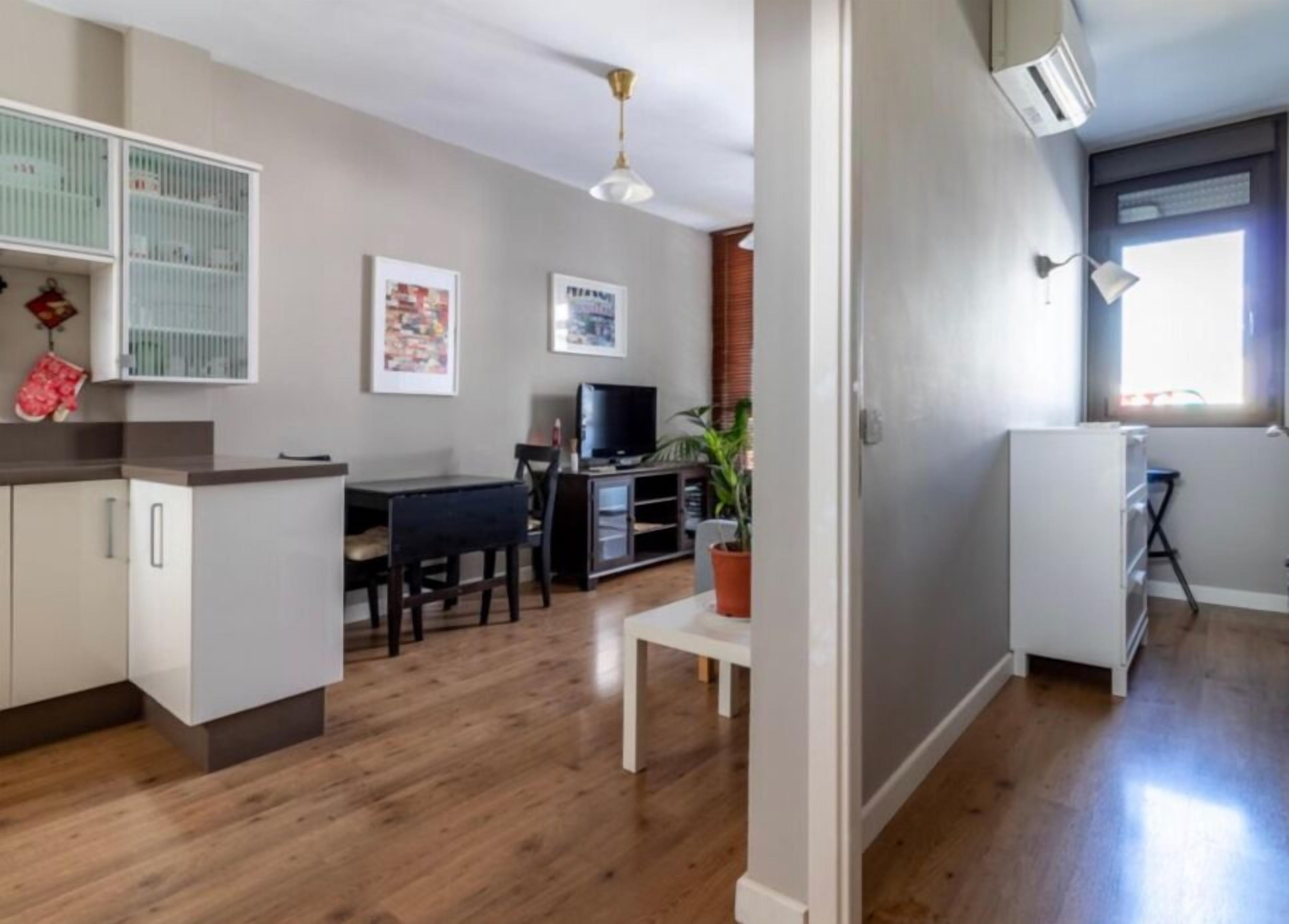 A modern apartment with a kitchen, dining area, and living space.