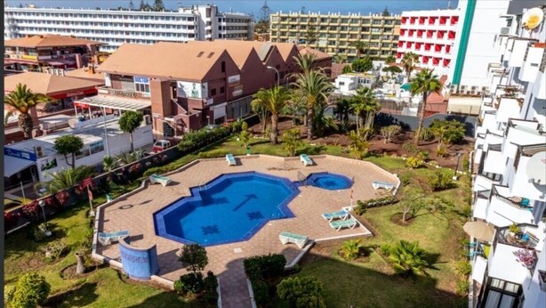 Un hôtel doté d’une piscine centrale, de nombreuses chambres et d’un jardin aménagé.