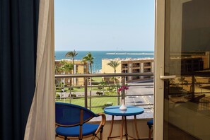 A balcony with a view of the sea, a table with a vase, and two chairs. - Helnan Mamoura Hotel & Events Center (Alexandria)