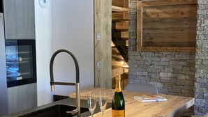 Een keukenblad met een fles Veuve Clicquot, twee glazen en een boek.