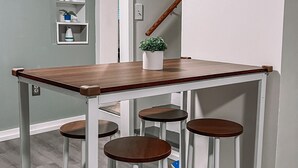 Une cuisine avec un ensemble de tabourets de bar en bois et un panneau mural sur lequel est écrit « ENDROIT IDÉAL ».