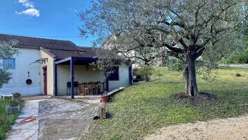 A house with a patio, a tree, and a grassy yard.