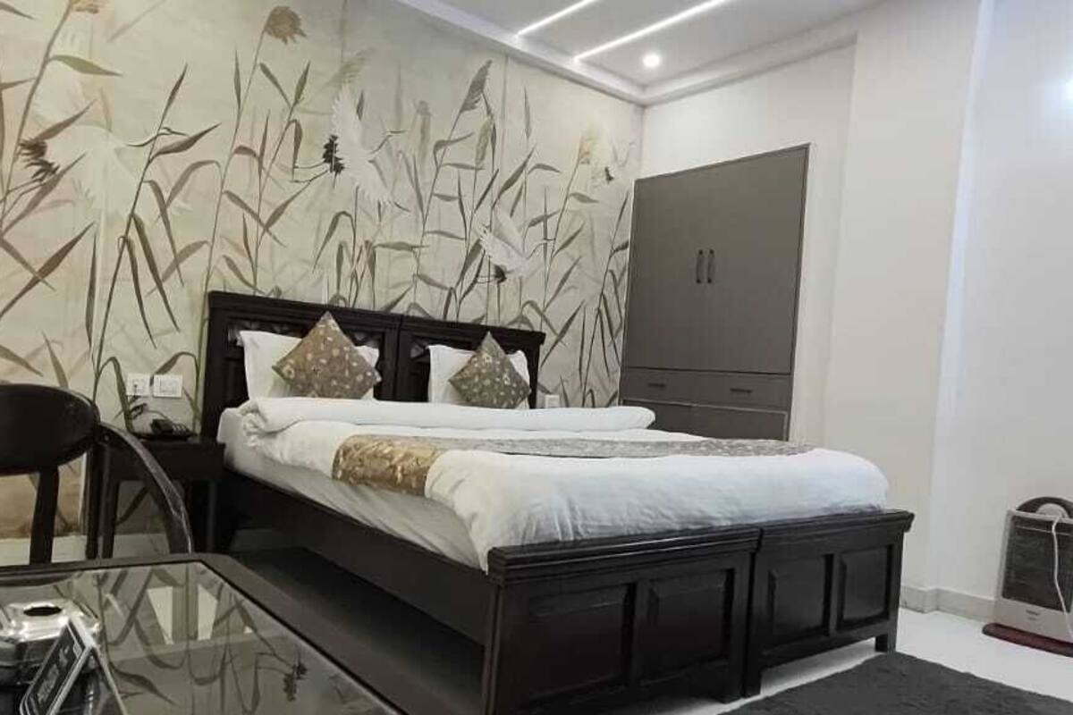 A bedroom with a bed, a chair, a bedside table, and a wardrobe.
