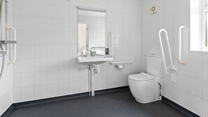 A modern bathroom with white tiles, a sink, a toilet, and a shower. - Lodge 5 - Lytton Tree Lodge, Reydon, Southwold (Reydon)