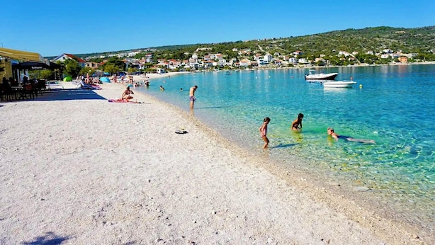 A beach with clear water, people swimming, and boats. - Holiday House Galeb - 20 meters from Beach! (Sevid)