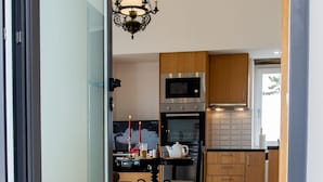 A modern kitchen with wooden cabinets, a stainless steel oven, and a black countertop. - Tradicampo-Quinta das Cycas-O Granel-360º Panoramic view - NEW LISTING  (Algarvia, Nordeste)