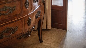 A wooden dresser with ornate handles, a red vase with white flowers, and a door leading to a room with a view. - Pleasant house with garden - Near downtown (Albi)