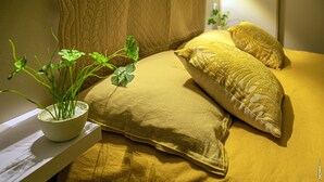 A bed with yellow bedding, a white bedside table, and a potted plant. - Pleasant house with garden - Near downtown (Albi)