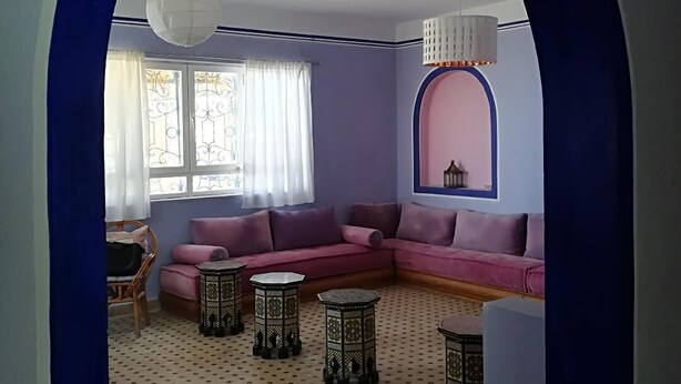 A living room with a pink sectional sofa, patterned floor, and a blue archway. - DAR CLARA, or DAR FKRUN (Double room) (Arcila-Mejlaw)