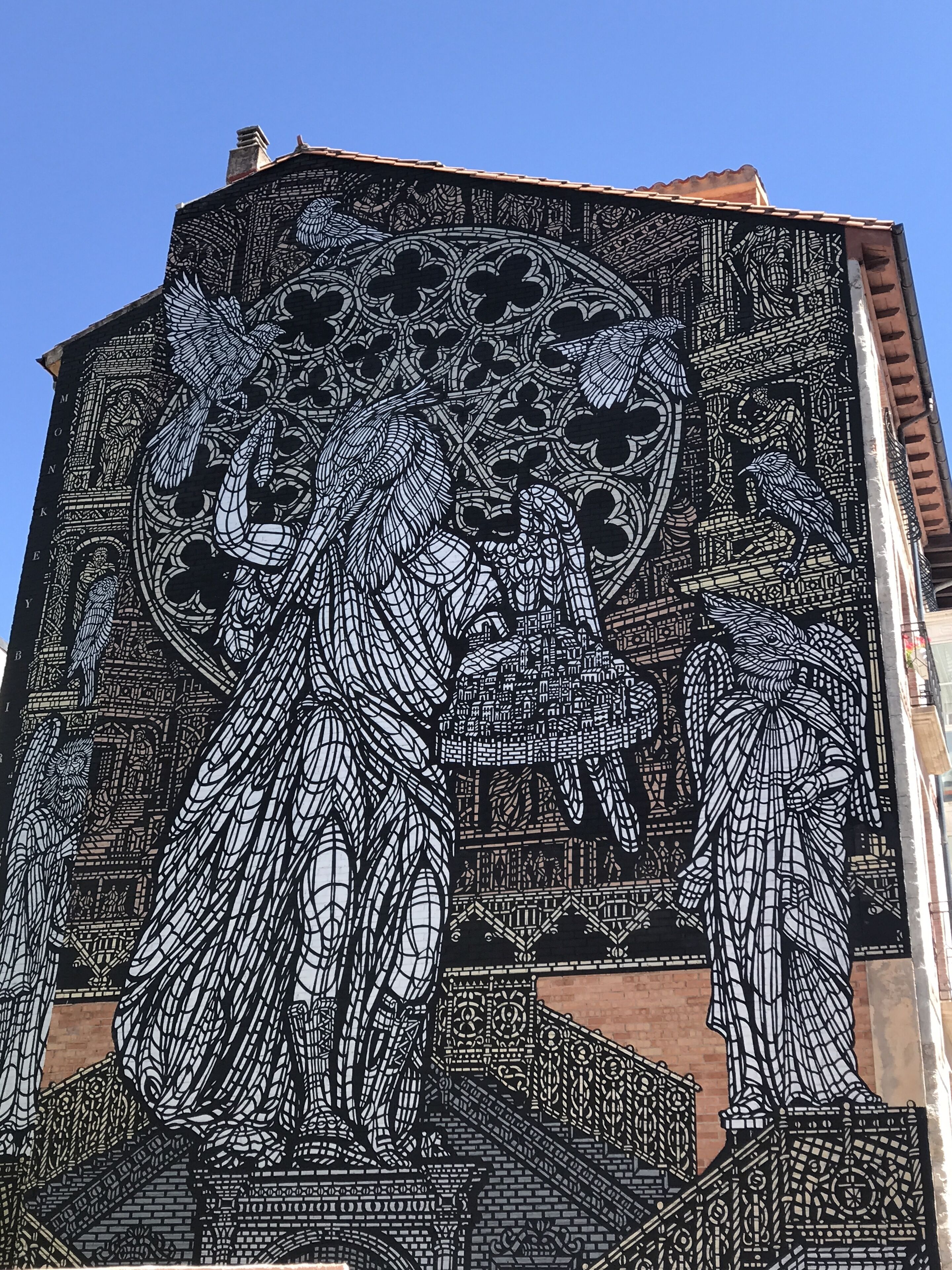 A detailed mural on a building's facade featuring intricate patterns and figures.