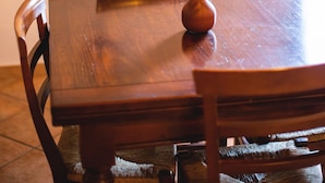 A wooden dining table with a vase of green foliage. - Leondardo Apartment ~ LE FRAINE (New Opening 2022) (Santa Luce)