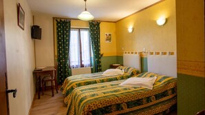 Une chambre avec deux lits, un bureau et une chaise.
