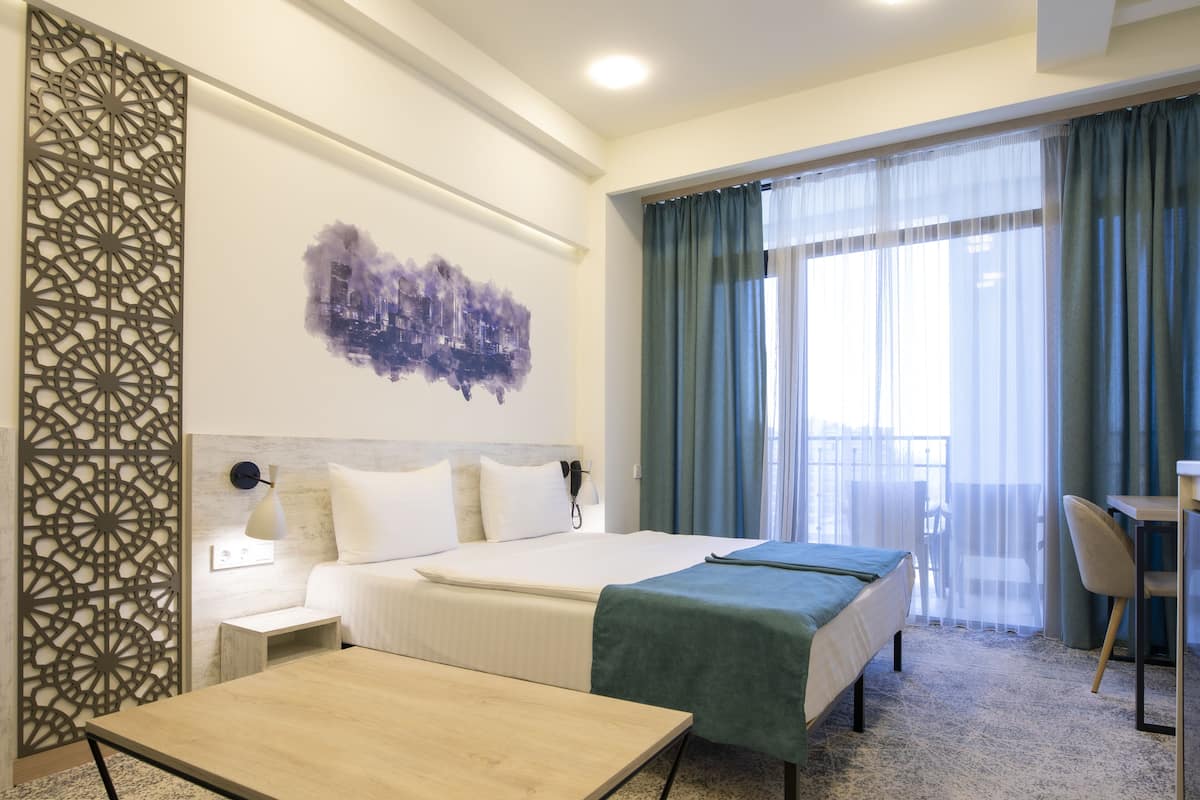 A hotel room with two beds, a desk, a chair, and a decorative wall panel.