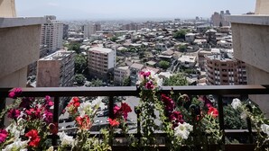 A balcony with a view of a cityscape through an arched window. - Rooftop Apart Hotel (Yerevan)