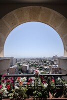 Un balcón con vista a un paisaje urbano a través de una ventana de arco.