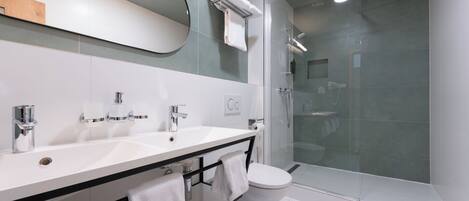 Une salle de bain moderne avec un lavabo blanc, un miroir et des toilettes.