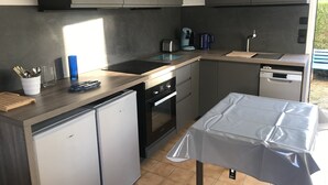 Una cocina compacta con horno integrado, cafetera y lavavajillas.
