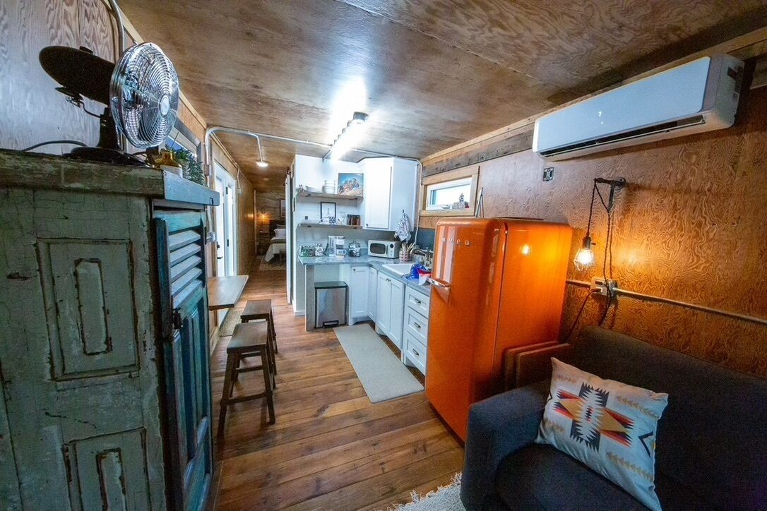 A compact kitchen with wooden cabinets, a refrigerator, and a microwave.