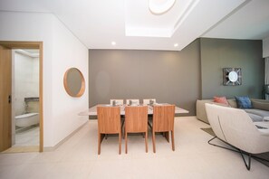 Un salon moderne comprenant une table à manger, des chaises, un canapé et une horloge murale.