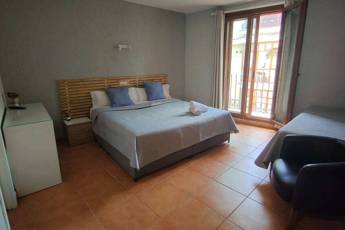 Un dormitorio con una cama, un escritorio y una silla.