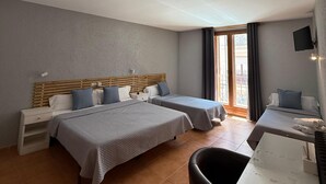 Une chambre d’hôtel avec deux lits, un bureau et une chaise.