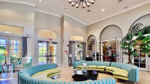 A spacious lobby with a curved seating area, a reception desk, and a view of the outside through large windows.