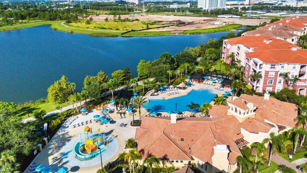 A resort with a large swimming pool, a water park, and a view of a lake.