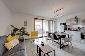 Een modern appartement met een woonkamer, eethoek en keuken.