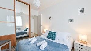 A hotel room with a bed, bedside tables, a mirror, and a wardrobe. - Le Boileau - Apartment for 4 people, parking and balcony, CLOSE to the Lake (Annecy)